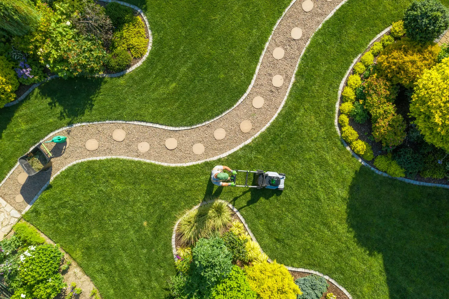 Rasenmähen im großen Garten durch kaukasischen Gärtner